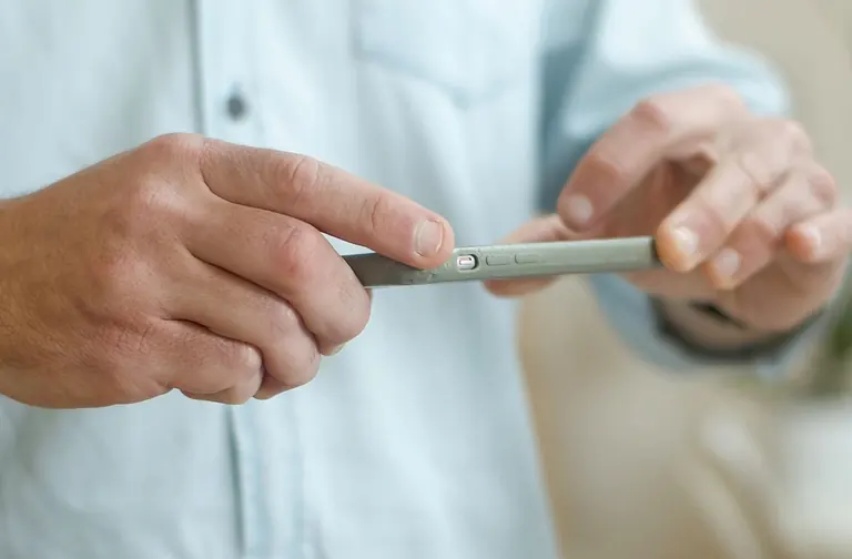 Person photographing a package with a smartphone