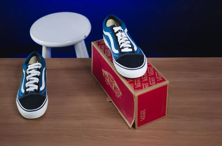 Shoes and their retail box on a wooden surface