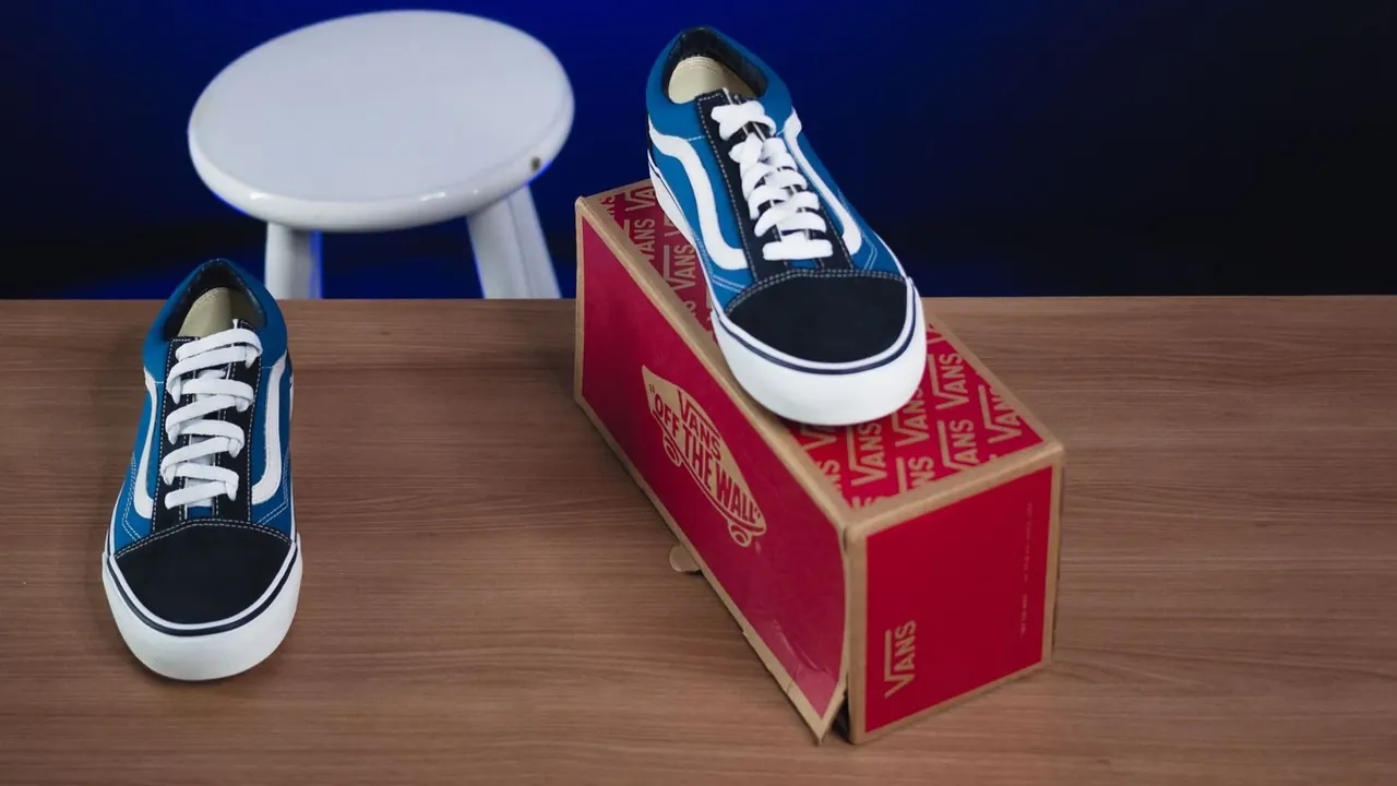 Shoes and their retail box on a wooden surface