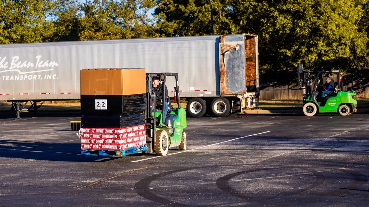 Forklift operators loading pallets onto a truck